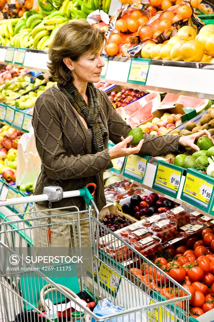Woman shopping in fruits and vegetables section in supermarket.