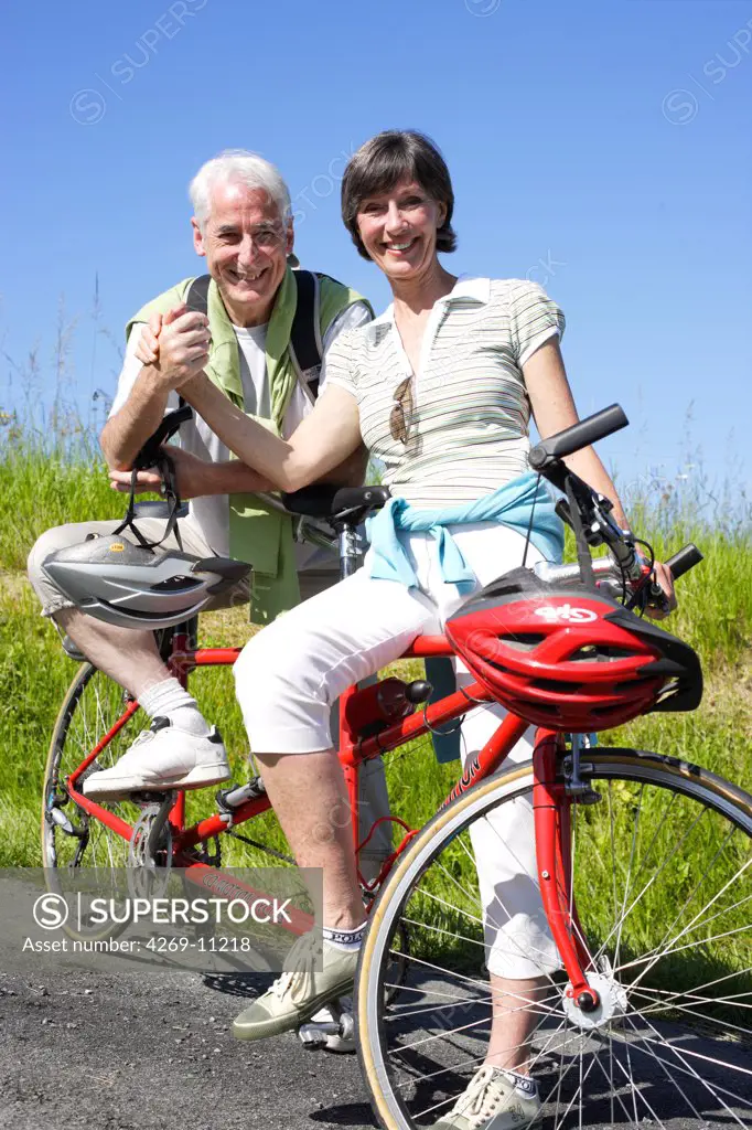 Senior couple riding tandem bicyle.