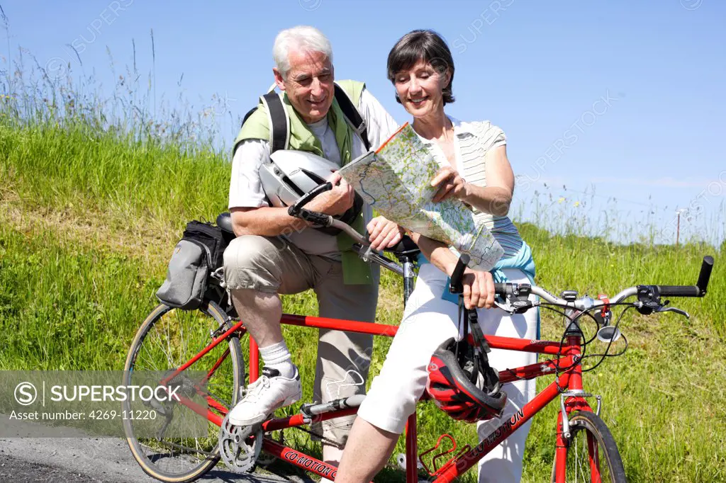 Senior couple riding tandem bicyle.