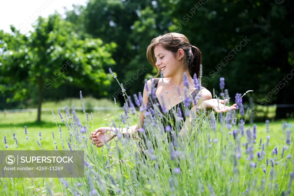 Young woman inhaling the scent of lavender.