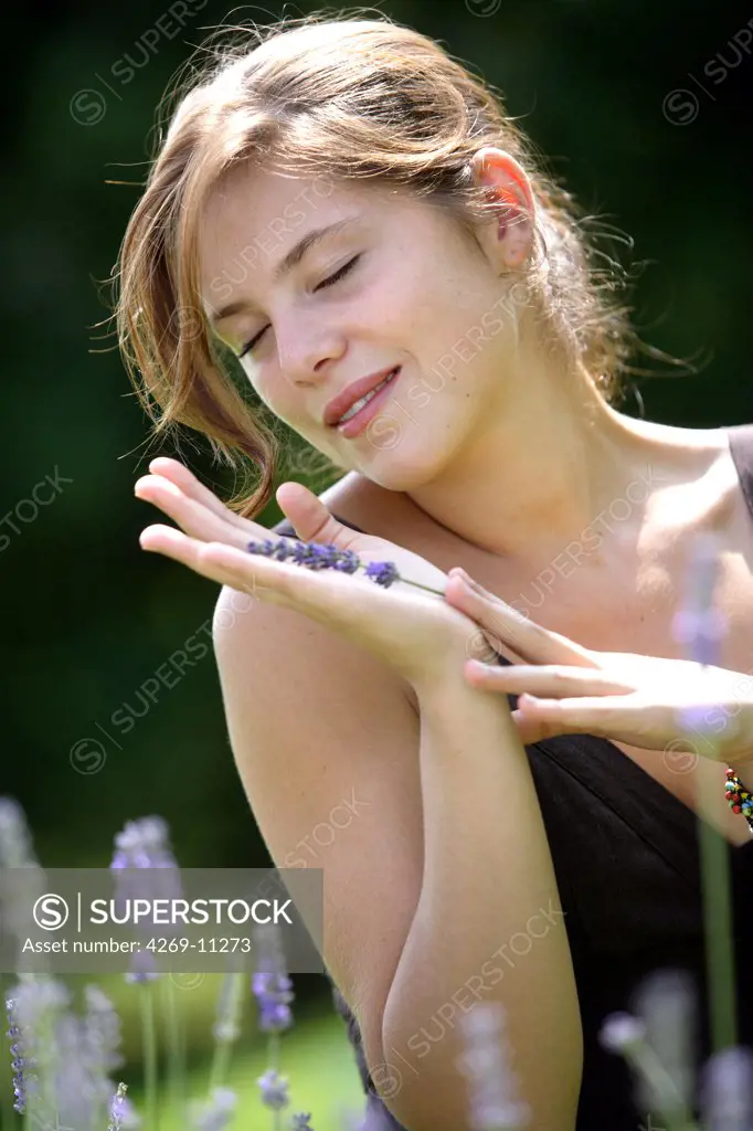 Young woman inhaling the scent of lavender.