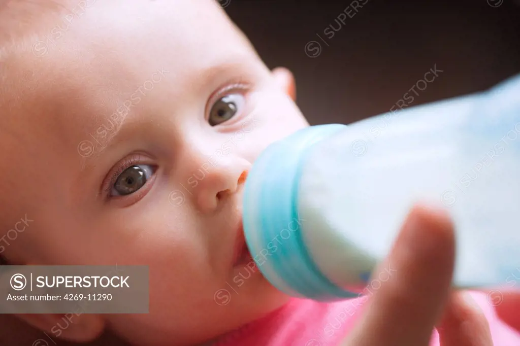 7 months old baby with feeding bottle.