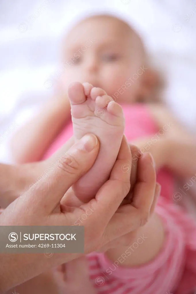 7 months old baby receiving foot massage.