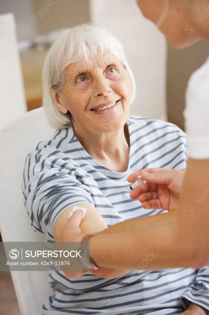 80 years old woman receiving vaccination against flu.