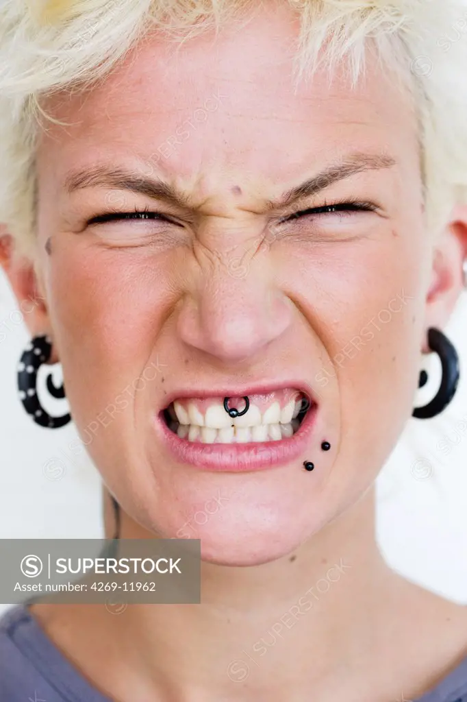Portrait of young woman with multiple piercings.