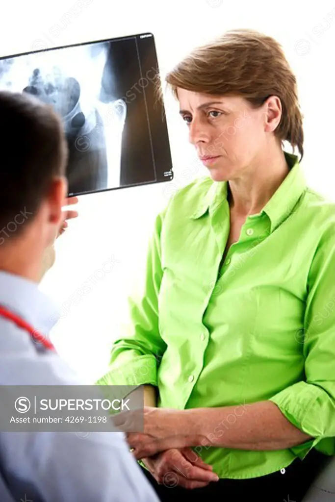 Doctor examining X-ray of hip prosthesis of a 50 years old patient