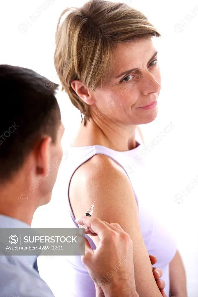 Woman receiving a vaccination from a doctor.
