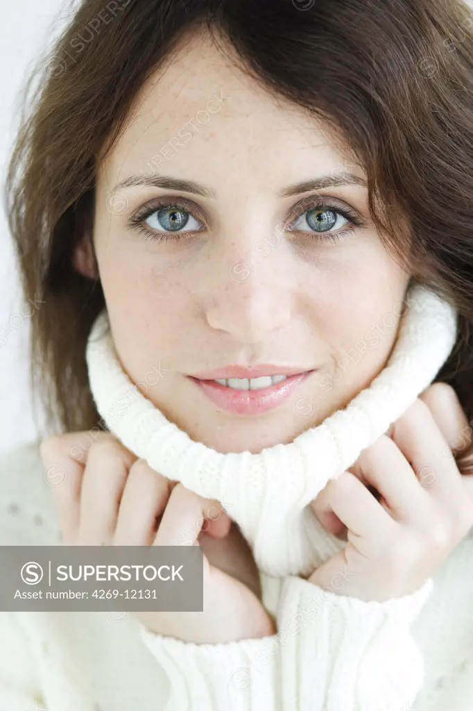 Woman bundling up in rollneck sweater.
