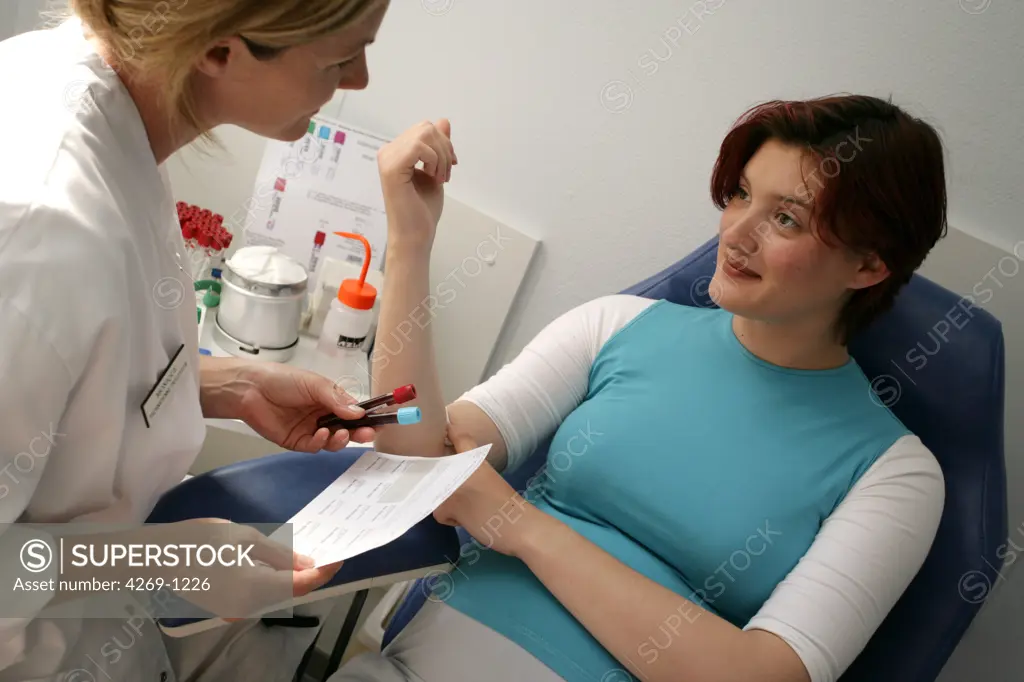 Nurse taking a pregnant woman's blood sample.