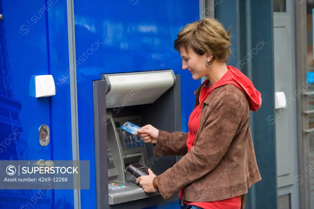 Young woman withdrawing money from a cash machine.