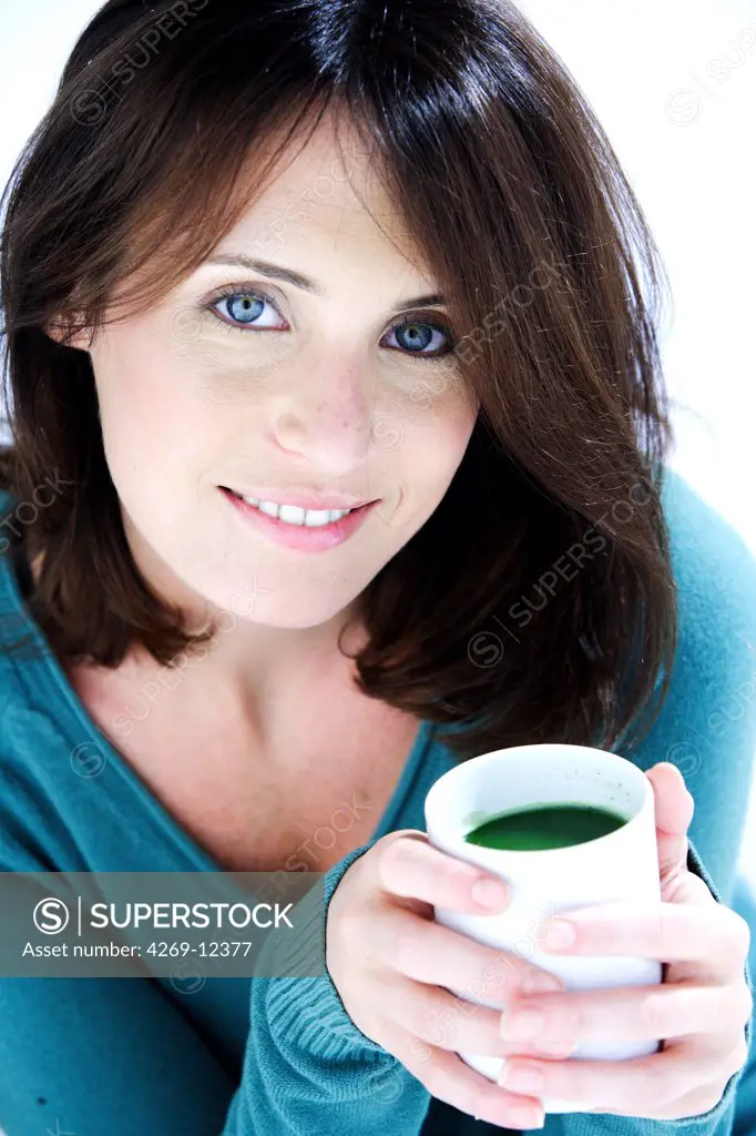 Woman drinking matcha, powdered Japanese green tea.