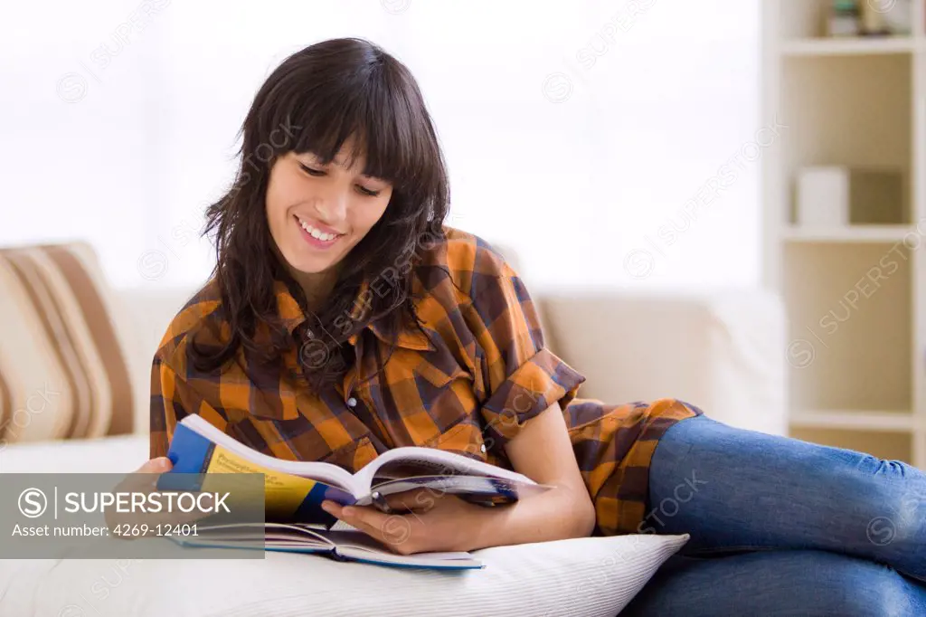 Teenage girl reading school book.