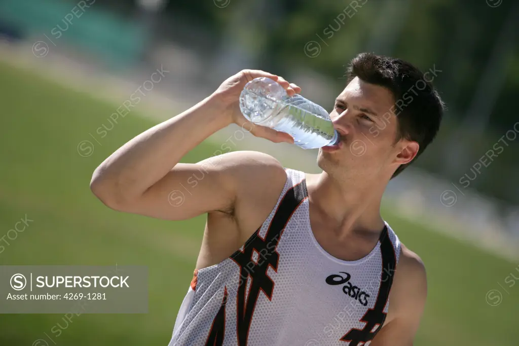Sportman still mineral water to rehydrate himself after exercising.