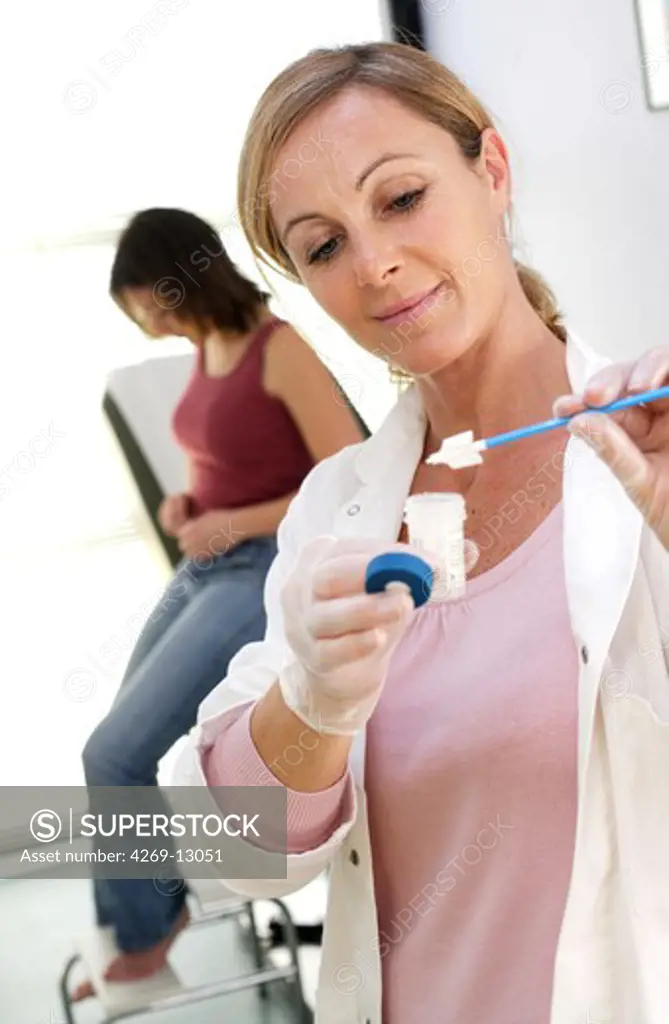 Gynecologist performing a cervical smear or pap test on a teenage patient.