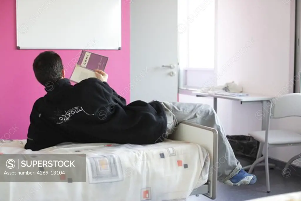 This newly renovated psychiatric hospitalization unit hosts patients with various mental disorders (psychosis, behavior disorder, schizophrenia, addiction, alcoholism, etc.) during the course of treatment. Psychiatry Unit managed by Dr Rachel Bocher, Nantes university hospital, France. Here schizophrenic patient reading in his room.