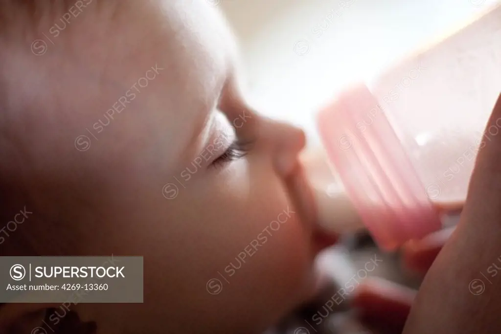 15 months old baby with baby-bottle.