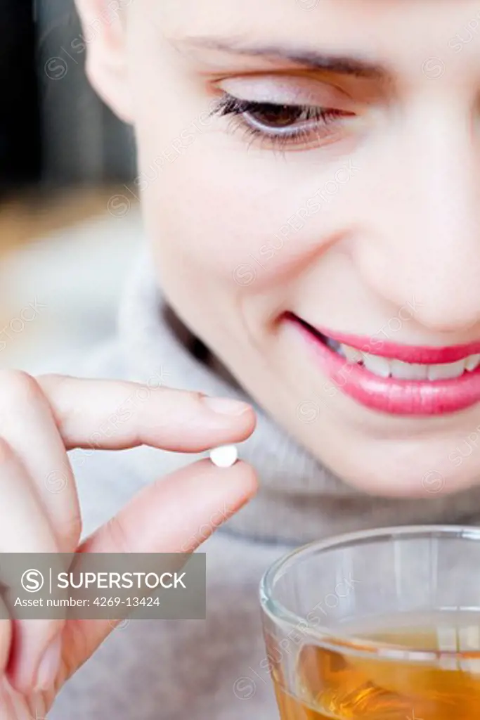 Woman adding artificial sweetener to hot beverage.