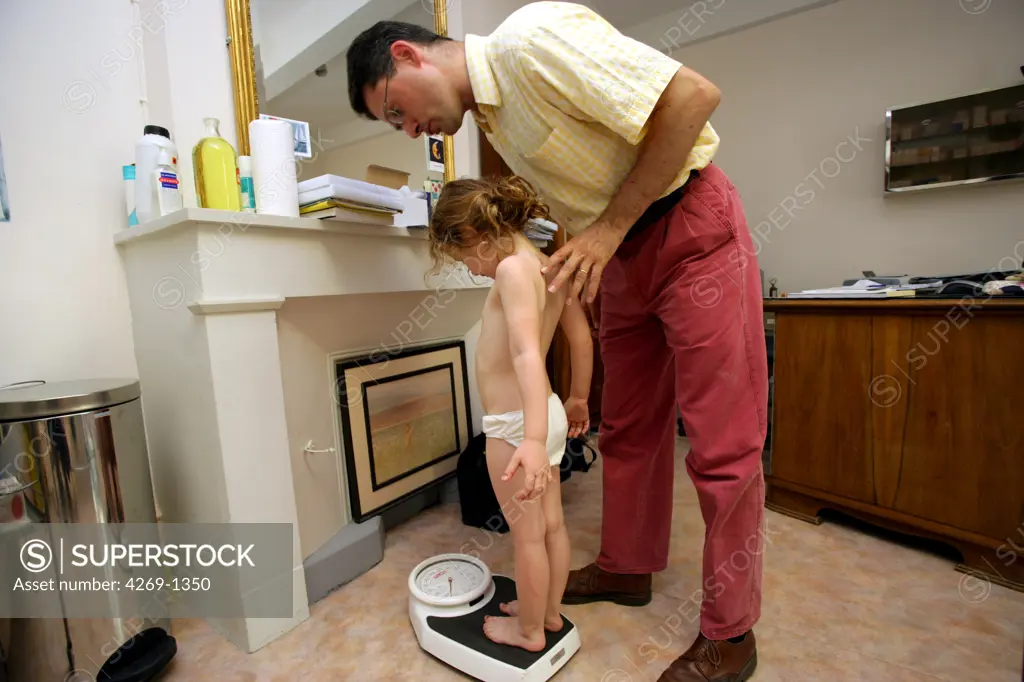 General practitioner checking the weight of a 3 years old girl during consultation.