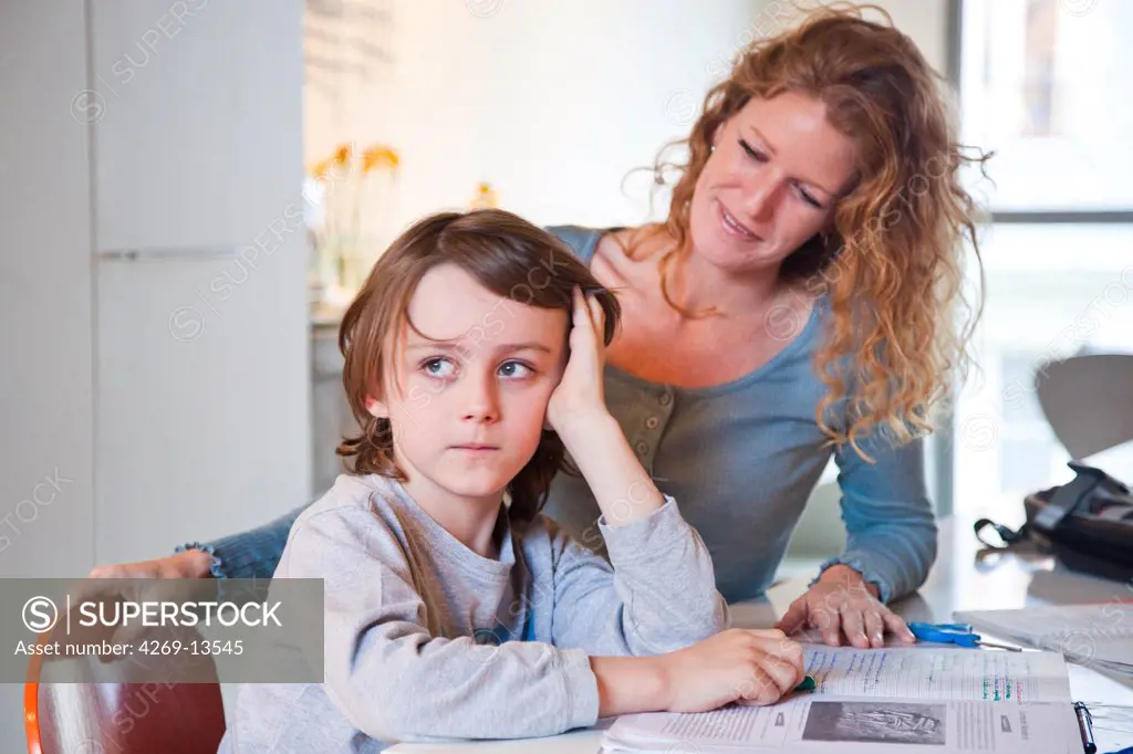 9 years old boy doing homework with his mother.