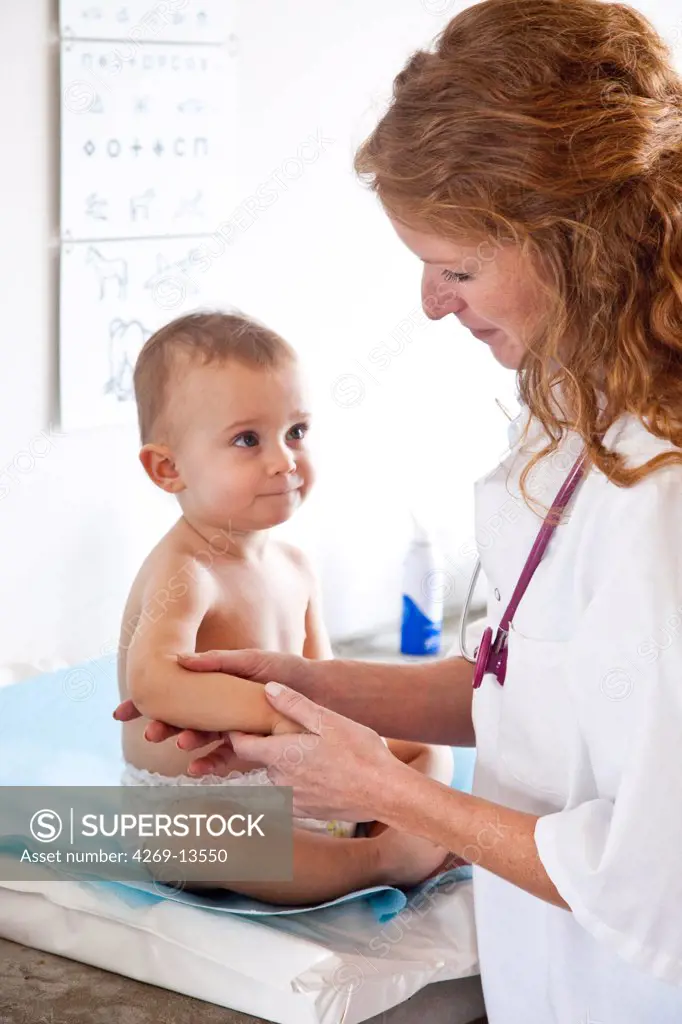 Pediatrician examining the skin of 15 months old baby.