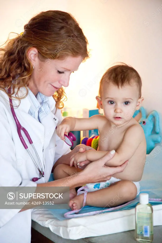 Pediatrician examining the skin of 15 months old baby.