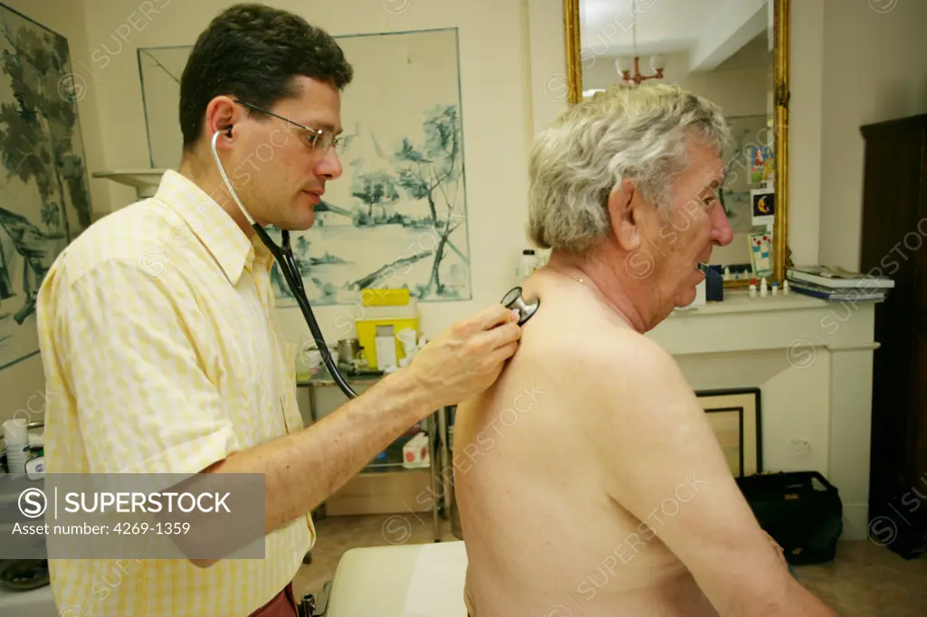 General practitioner examining the back of a 65 years old patient with stethoscope.