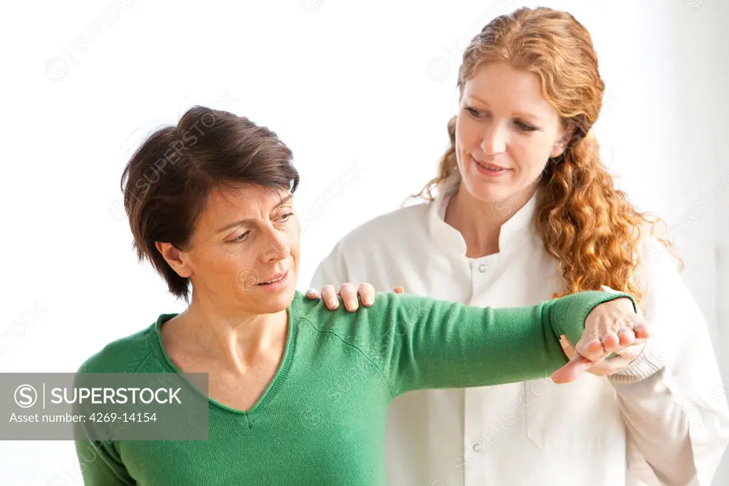 Physiotherapist examining patient's shoulder.