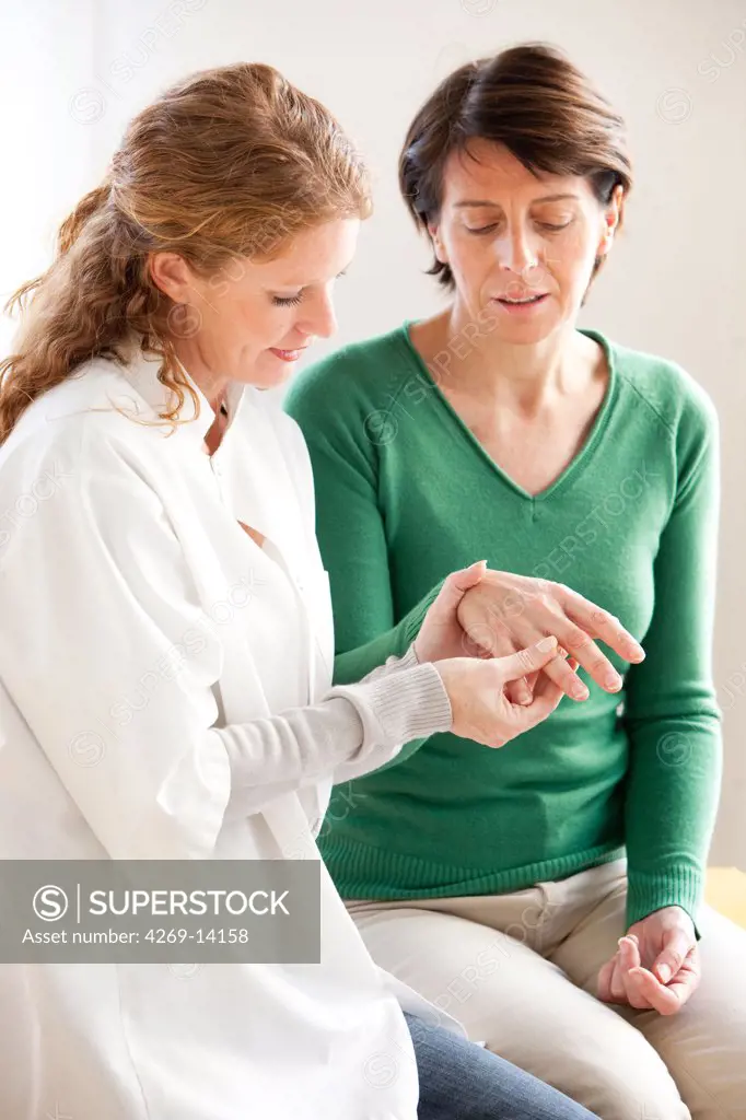 Physiotherapist examining patient's wrist.