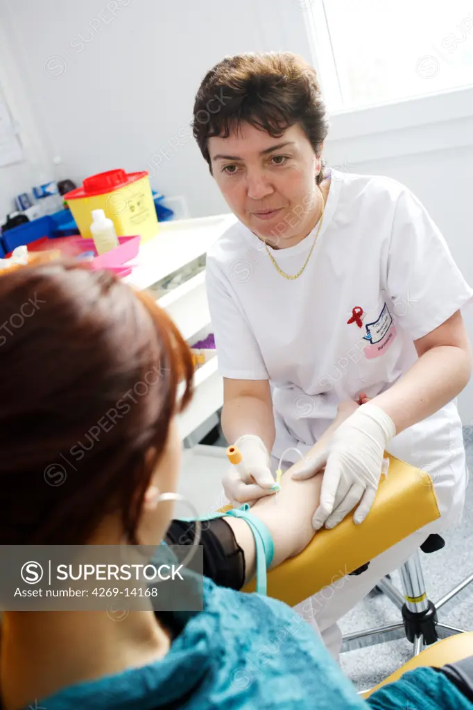 Nurse taking blood sample form patient's arm. Anonymous and Free Screening Center, Infectious and Tropical Diseases Department, Limoges hospital, France.