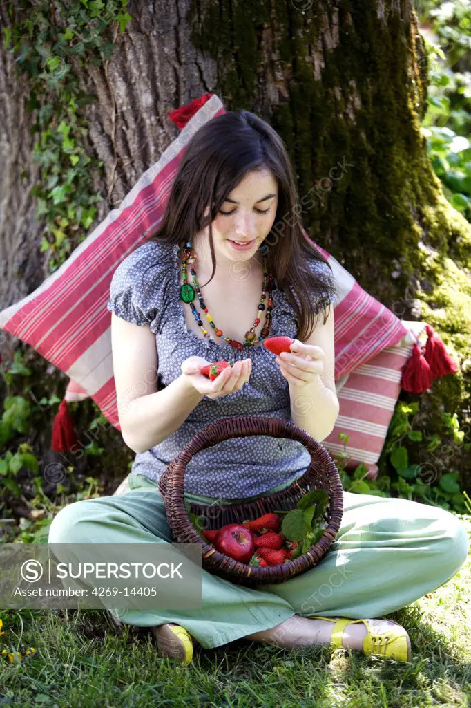 Young woman eating strawberries.