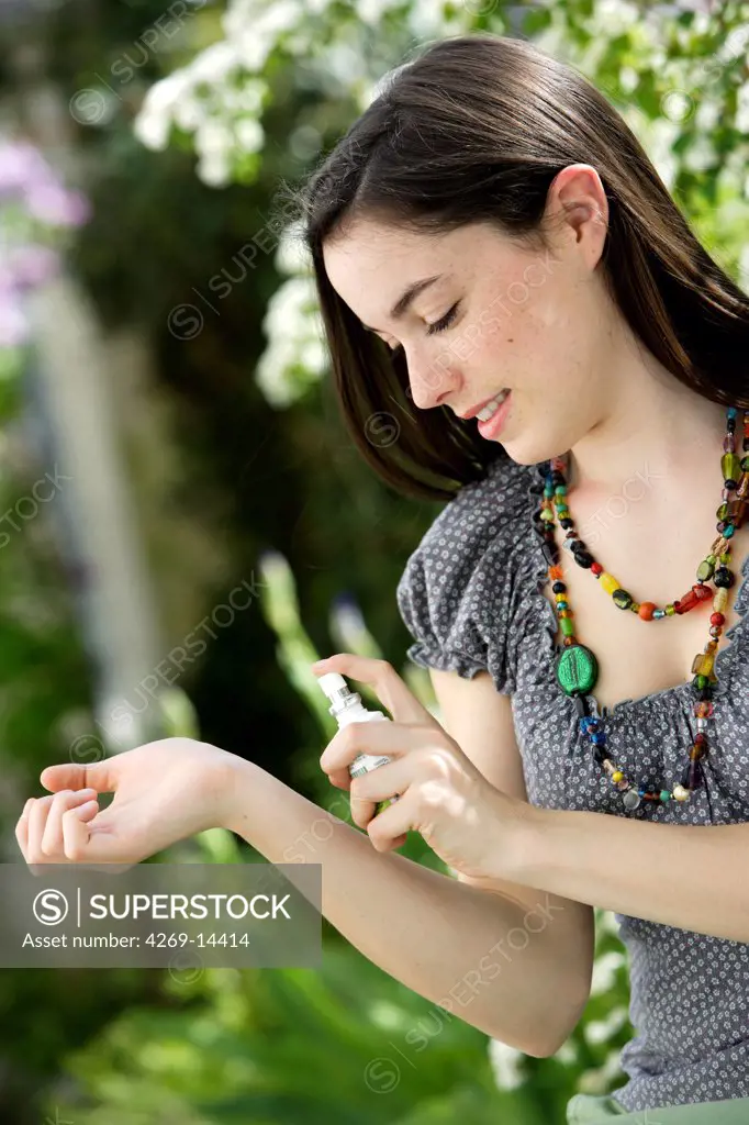 Woman using a spray against hitching and insect bites.