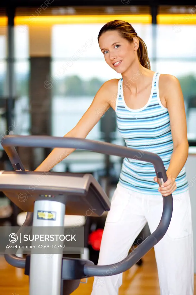 Woman exercising with a stepper at the gym.