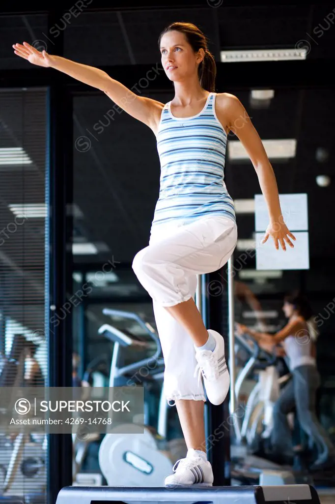 Woman doing step exercises at the gym.