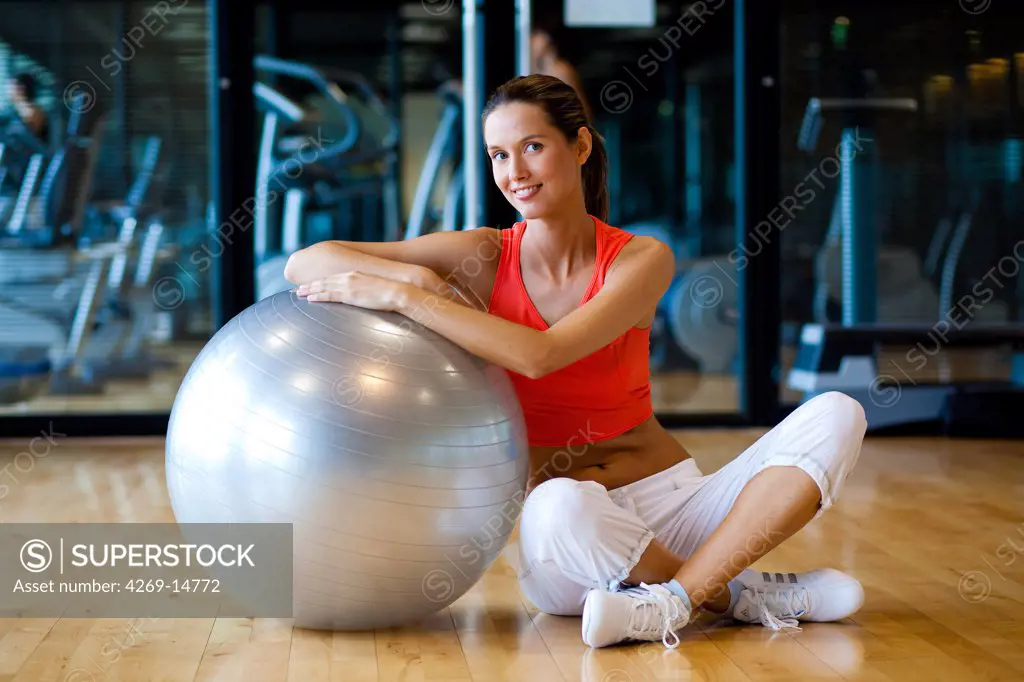 Woman with excercise ball in a gym.
