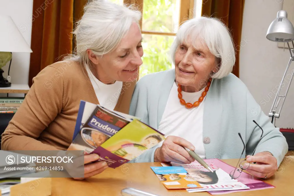 Elderly woman reading information leaflet.