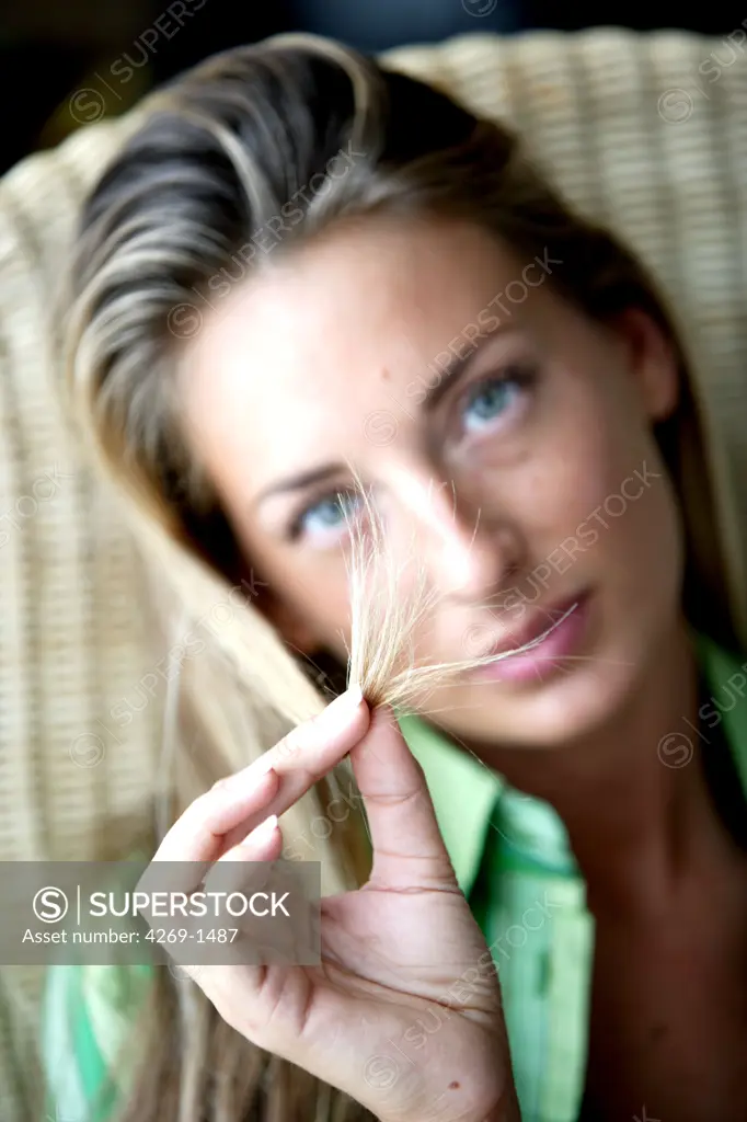 Woman checking the tip of her hair.