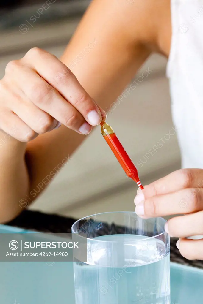 Woman holding glass ampoules of trace elements.