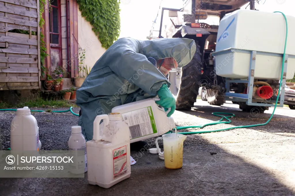 Farmer mixing Novartis® chemicals (Callisto, Milagro) to spray on corn fields. He is wearing protective suit and mask. This farmer uses sustainable farming practises in using reasonable amount of inputs (herbicides, pesticides).
