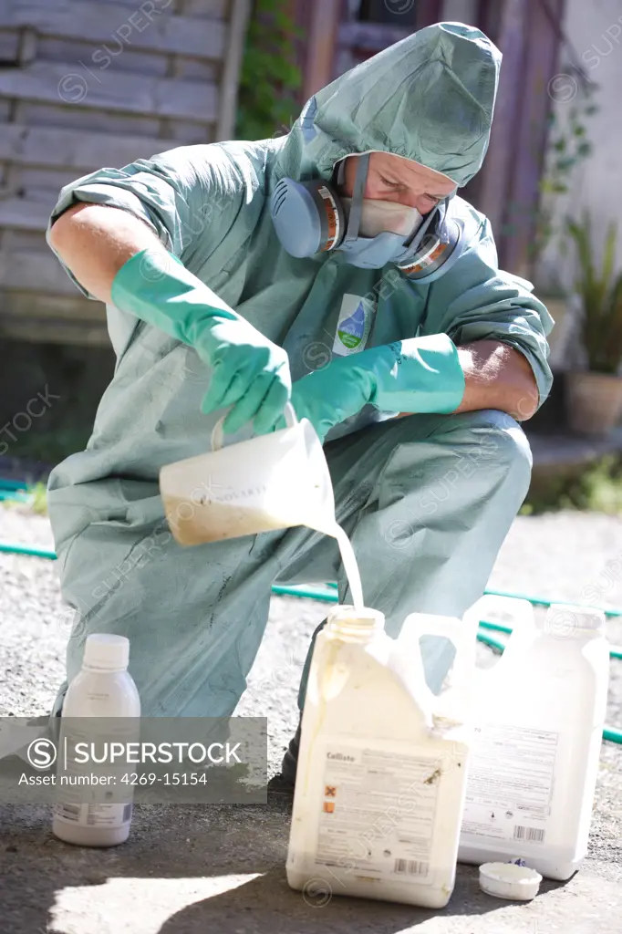 Farmer mixing Novartis® chemicals (Callisto, Milagro) to spray on corn fields. He is wearing protective suit and mask. This farmer uses sustainable farming practises in using reasonable amount of inputs (herbicides, pesticides).