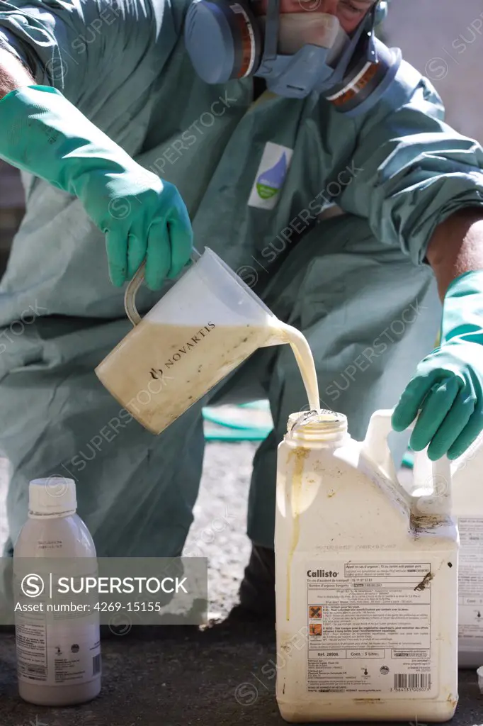 Farmer mixing Novartis® chemicals (Callisto, Milagro) to spray on corn fields. He is wearing protective suit and mask. This farmer uses sustainable farming practises in using reasonable amount of inputs (herbicides, pesticides).