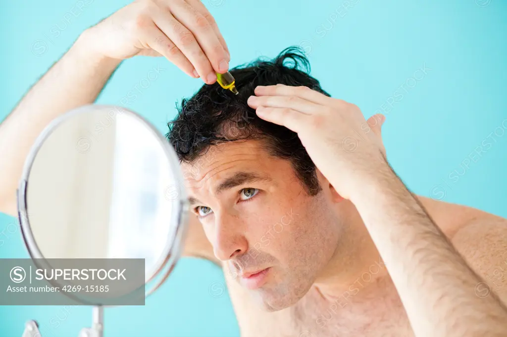 A man uses hair lotion to prevent loss of hair.