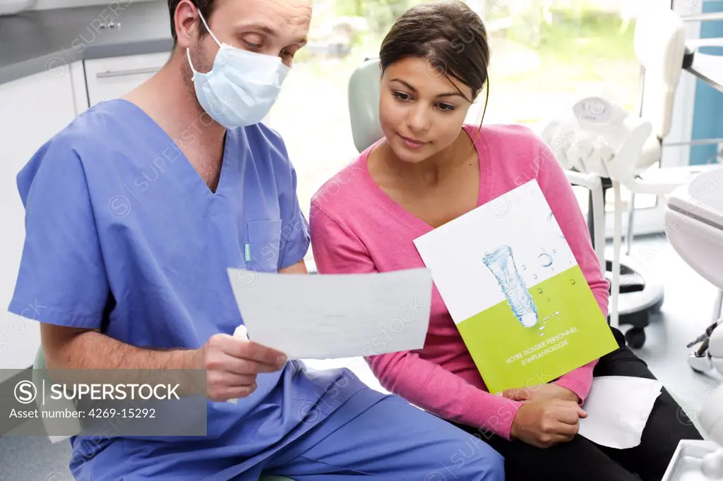 Dentist informing patient on dental implants.