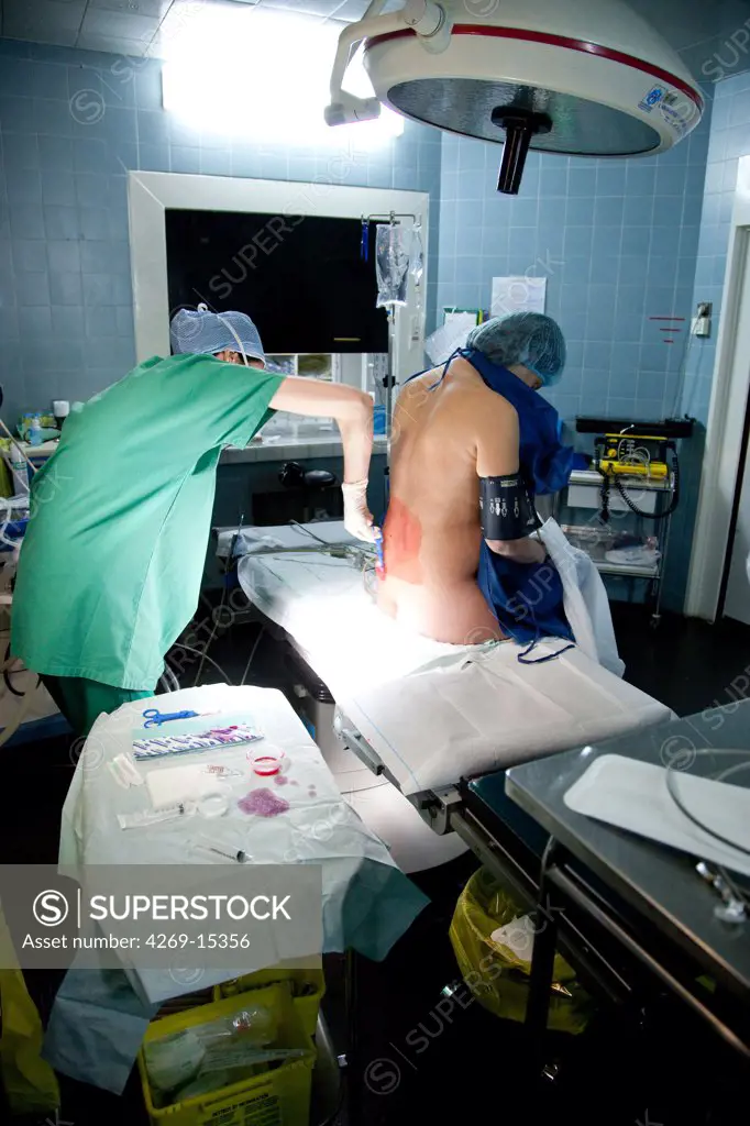Woman receiving epidural anaesthesia before delivery. Maternity department, Cochin hospital, Paris, France.