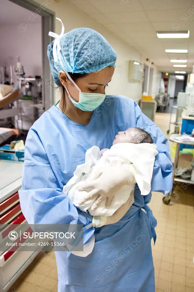 Student midwife with a newborn baby. Maternity department, Cochin hospital, Paris, France.