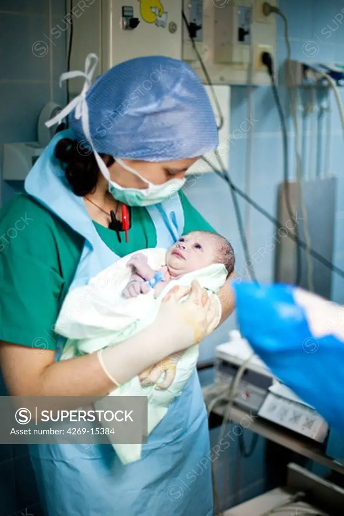 Delivery. Midwife with a newborn baby. Maternity department, Cochin hospital, Paris, France.