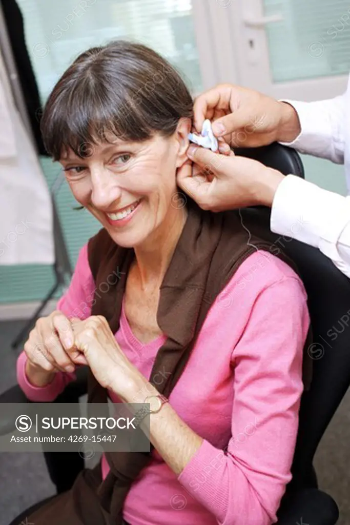 Hearing aid specialist making an impression of the auditory canal and eardrum of the patient before making the hearing aid.