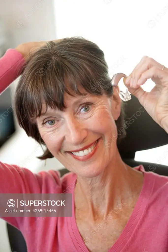 Woman fitting a digital hearing aid.
