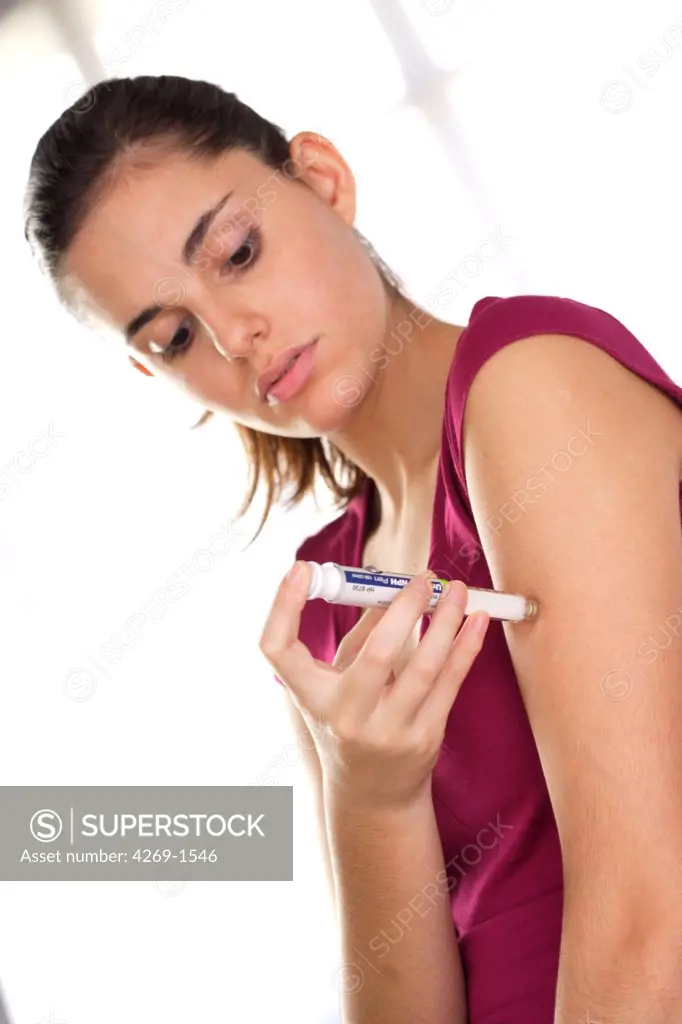 Woman giving herself an insulin injection with an insulin pen to treat Diabetes.
