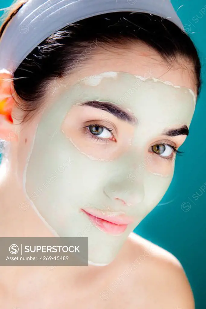 Woman wearing green clay cosmetic beauty mask.