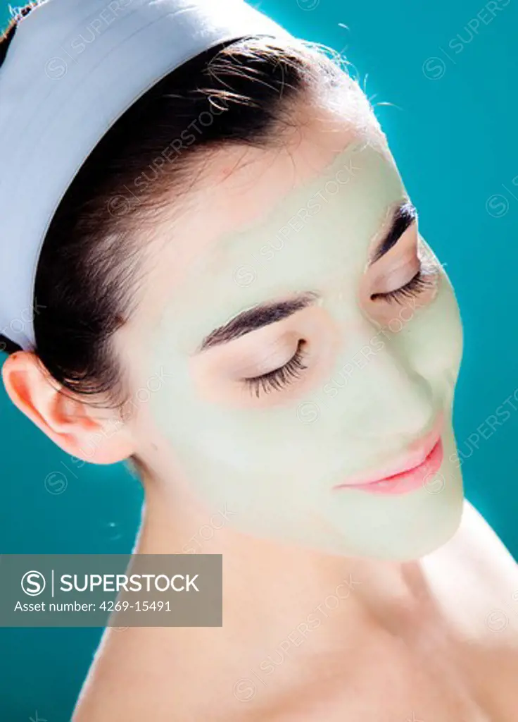 Woman wearing green clay cosmetic beauty mask.